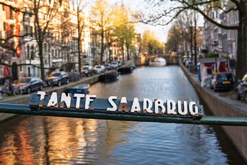 Experience the beauty of Amsterdam with this view of Tante Saarbrug bridge. The peaceful canals...