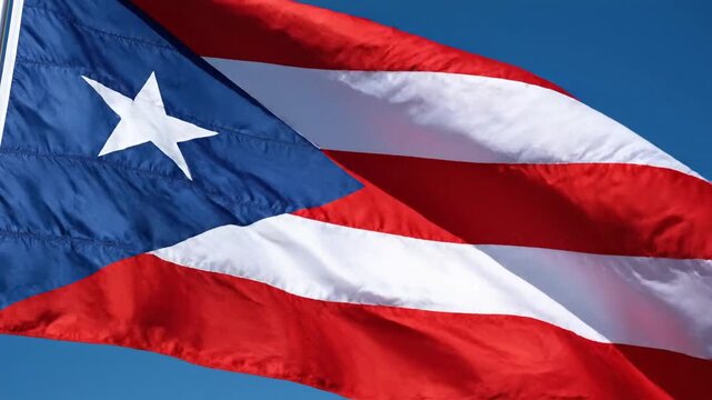 Cinematic slow-motion shot of the Puerto Rican flag featuring creased satin fabric fluttering in the wind displaying intricate seams and wrinkles on this vibrant national Caribbean symbol.