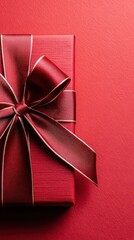 Close Up of Red Gift Box with Golden Ribbon on Textured Red Background for Festive Holiday Celebration