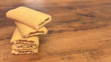 Homemade fig newtons cookies on rustic wooden table &ndash; soft layered fig bars with golden crust and copy space