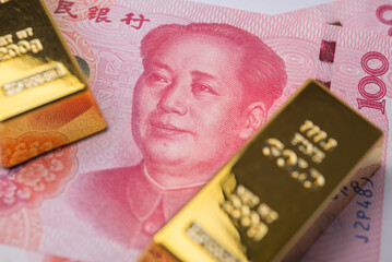 Gold bars with Chinese yuan bill banknote. Central bank of republic of China keeps gold reserves, gold price increase all time high, global finance and commodity trading market investment concept.