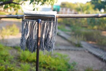 The mop is hung on a bamboo rack.