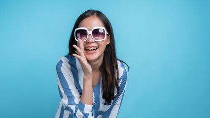 Naklejka premium Smiling Woman Wearing Sunglasses on Blue Background