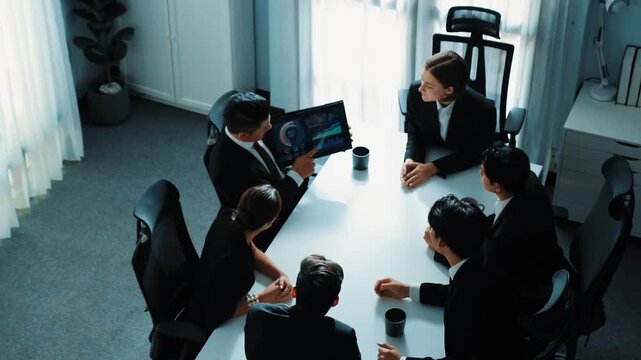Top view of professional project manager present financial graph while holding tablet. Diverse group working together to analyze stock market investment data graph ay business conference. Directorate.