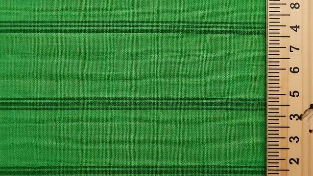 Green fabric with measurement ruler - Powered by Adobe