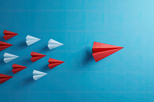 Red paper plane change direction from group hitting to target on blue background. Design for business creativity new idea to discovering new business options, Individual and unique leader. paper art 