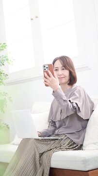 スマホで顔認証や画に向かって話すシニア女性の縦動画