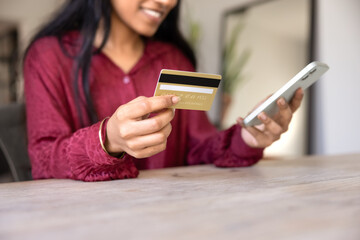 Happy young Indian shopper using credit card and bank application, financial service for smartphone for online shopping, checking cashback, account, paying bills. Cropped close up shot