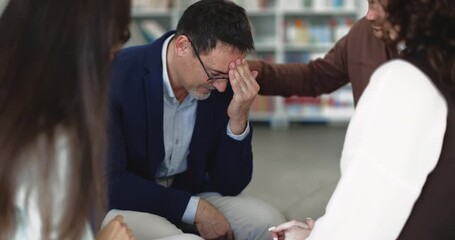 Man receiving emotional support from group members during psychological session, participant touch his shoulder as sign of compassion and empathy. Mental health crisis, therapy meeting of community