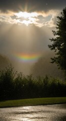 Bright sun rays pierce dark clouds during a localized rain shower featuring a faint horizontal atmospheric optical phenomenon