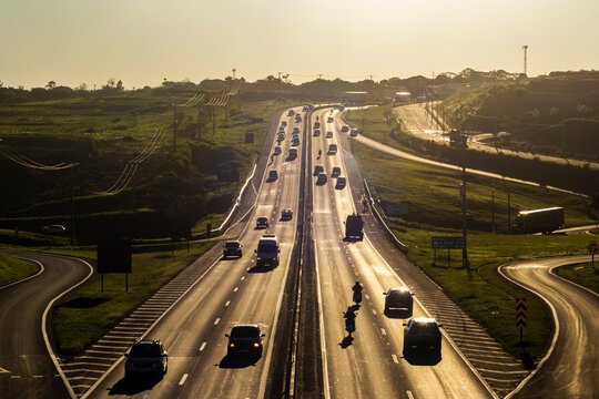 Marilia, SP, Brazil, November 19, 2025. Highway SP-294 in Marilia, at sunset. Intense traffic of cars and trucks flows through the green landscape, illuminated by the golden hour light.