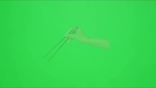 Vibrant chopsticks rest on wooden bowl against green