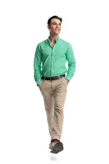 Naklejka premium Cheerful young man walking forward looking to side