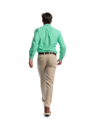 Fototapeta premium Back view of casual young man walking