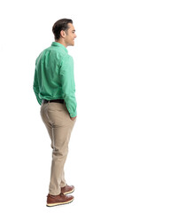 Fototapeta premium Side view of cheerful man standing with hands in pockets