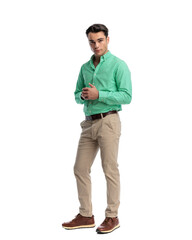 Fototapeta premium Confident young man standing with hands clasped