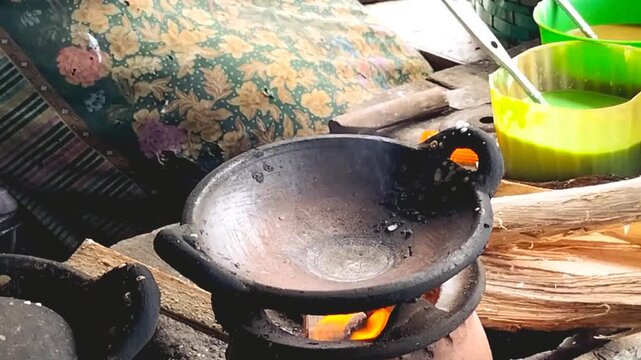 Footage of a woman's hands cooking Serabi Ngampin on a hot pan outdoors. Indonesian food. Traditional Indonesian Serabi.
