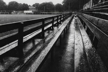 Wet Stadium Benches After Heavy Rainfall with Water Droplets on Surfaces