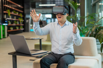 Mature business man programmer software developer using headset app making a presentation. Watching virtual reality 3D 360 video. Middle-aged guy manager in shirt in VR goggles working at office lobby