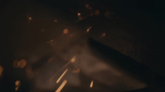 Fiery sparks shower during industrial metal grinding process.