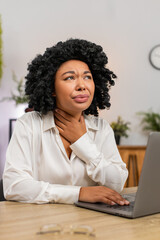 African American businesswoman at home office holds throat struggling to swallow enduring sharp...