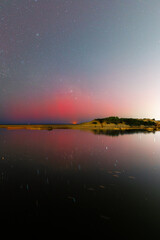 Red beam of Aurora Australis at the beach.