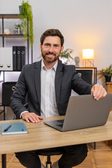 Middle-aged businessman at home office opens laptop happy for start of day begins typing fast with...