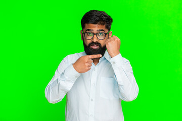 Indian man clenches fist in front with intense expression, showing strength, threat clear determination. Arabian guy isolated on green chroma key background expressing power, force emotional defiance