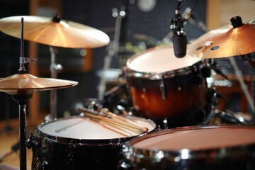 Obraz premium Exploration of a professional music recording setup featuring a detailed view of a drum kit and microphones in a studio environment in the evening