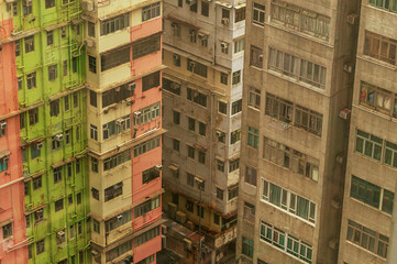 Street view of crowded public housing apartments in Hong Kong featuring old-school colorful exterior paint inspired by 1970s architectural style.