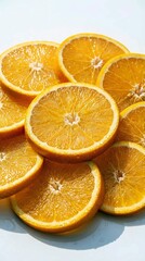 Fototapeta premium Freshly sliced oranges stacked on white surface