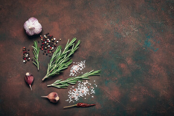 Close up of rosemary, garlic and spices on dark rustic background, culinary background, cooking ingredients, top view, flat lay