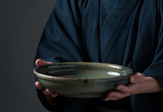 皿を持つ陶芸家の男性