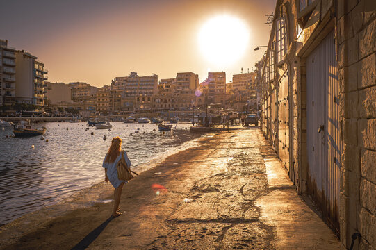 Beautiful, scenic view of the sunset over Spinola Bay in Saint Julian's (San Ġiljan), Malta, with lots of fishing boats anchored in the bay