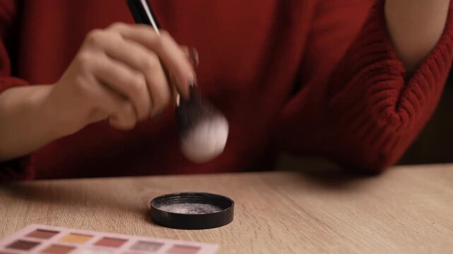 Brush puts in brown-beige bronzer for make-up. Cosmetic, powder, bronzer