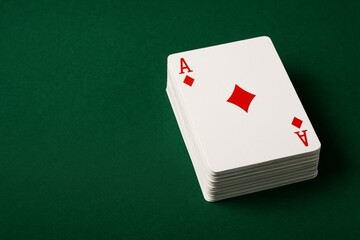 Stack of playing cards with ace of diamonds on top placed on green table surface, symbolizing gambling, luck, and strategy in gaming concept. Ai generative