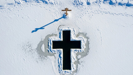 Ice cross in snowy landscape with reflection and cross on top 