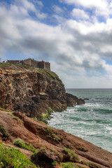 View onto the Fort Sao Miguel Arcanjo and the lighthouse Farol de Nazare in Nazare, Portugal.