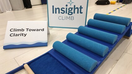 Insight Climb Workshop Activity Area with Blue Foam Rollers and Clarity Sign on Floor Surface