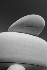 Minimalist Black and White Architecture Detail of Curved Organic Disc Structures with Textured Stone Surface