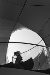 Woman Silhouette on Modern Spiral Staircase Inside Futuristic Architecture with Geometric Curved Design in Black and White