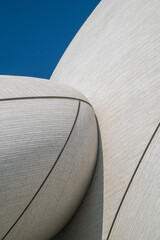 Abstract Curved White Stone Architecture Detail with Interlocking Organic Disc Shapes Against Blue Sky