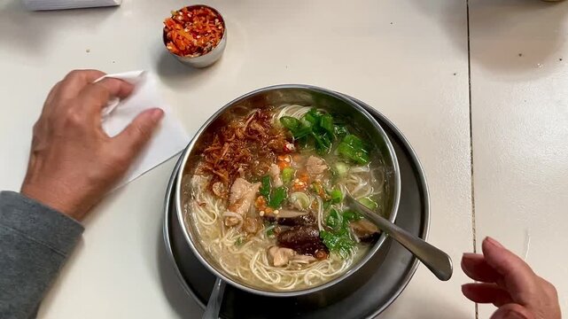 Indonesian food, Mie Ayam or chicken noodle. Noodle topped with chicken meat, leek, fried onions and sliced ​​cayenne pepper.