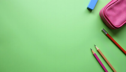 Back to school concept with school supplies on green background. Art and education for children. Colorful pencils and a pencil case.
