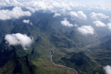 Aerial View of Lush Green Valley with Winding River Under Cloudy Sky and Distant Mountain Peaks Landscape in Daylight
