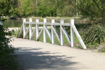 Kleine Br&uuml;cke &uuml;ber einen Teich mit einem wei&szlig;en Holzgel&auml;nder
