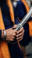 Fototapeta premium Sikh man in uniform holding a traditional curved sword, detailed hands and wristband