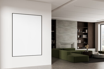 Naklejka premium Minimalist interior with large blank poster frame on white wall and modern living room featuring green sofa, bookshelf, and stone textured fireplace wall. 3D Rendering