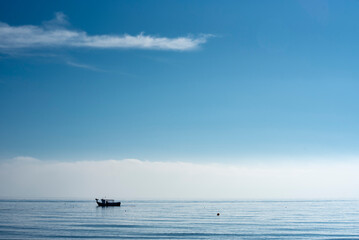 A small fishing boat fishing near the beach