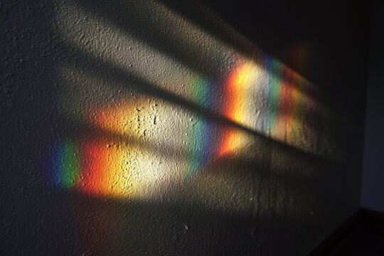 Subtle rainbow light reflections on a wall, creating a soft, abstract composition with delicate colors and natural atmosphere